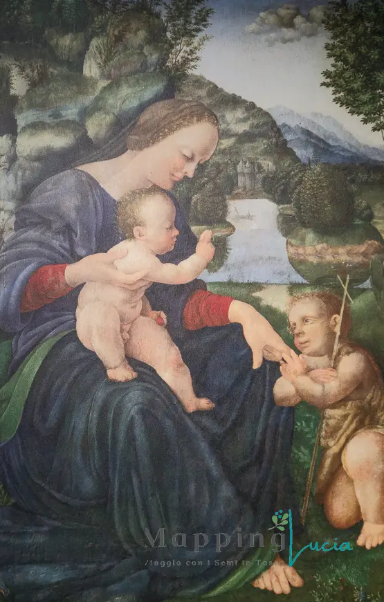 dipinto-madonna-con-bambino-in-braccio-e-un-putto-seduto-ai-suoi-piedi-la-madonna-tiene-tra-le-dita-una-ciliegia-sullo-sfondo-un-pesaggio-di-rocce-e-acqua